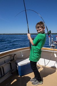 young boy fishing on a charter for lake trout